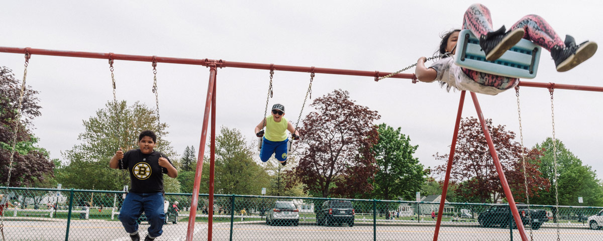 Children play on the swings at the St. Charles School in Rochester, NH.